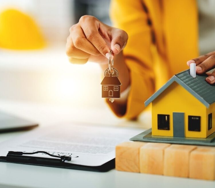 A hand holding up a set of house keys