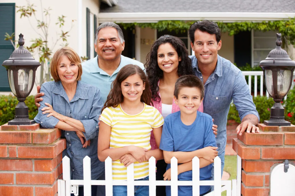 Una familia extensa se reúne en la puerta de su casa.