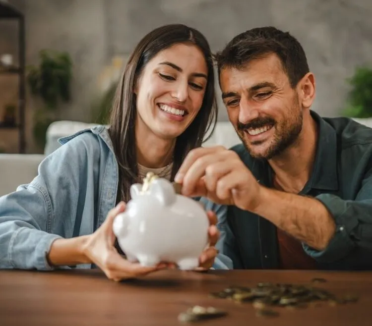 couple putting money into a piggy bank