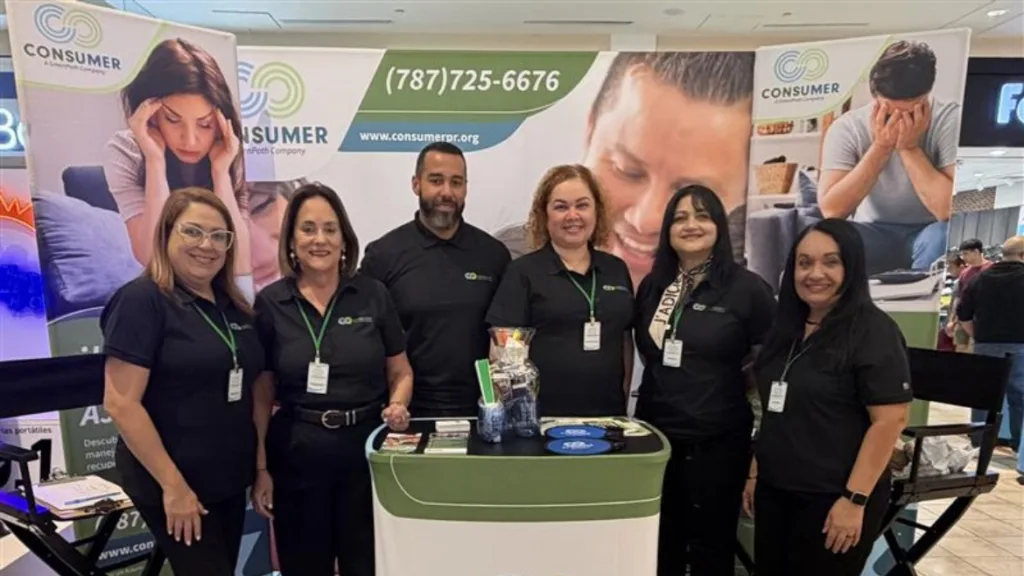 Consumer team standing behind a podium at a conference.